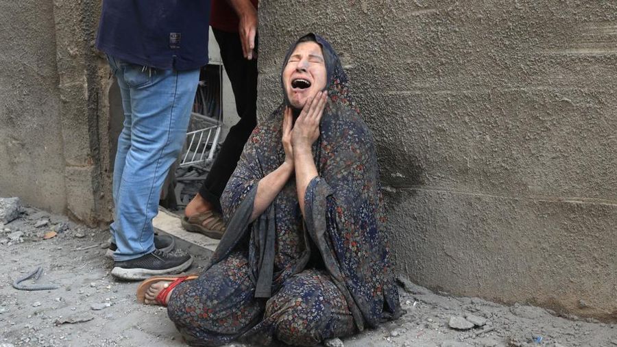 Orang-orang berkumpul saat warga Palestina berupaya mengeluarkan korban dari bawah reruntuhan rumah yang hancur akibat serangan Israel, di Khan Younis di selatan Jalur Gaza 17 Oktober 2023. (REUTERS/Ahmed Zakot)