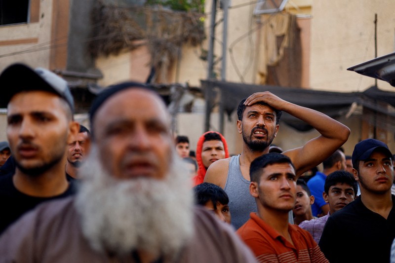 Orang-orang berkumpul saat warga Palestina berupaya mengeluarkan korban dari bawah reruntuhan rumah yang hancur akibat serangan Israel, di Khan Younis di selatan Jalur Gaza 17 Oktober 2023. (REUTERS/Ahmed Zakot) Orang-orang berkumpul saat warga Palestina berupaya mengeluarkan korban dari bawah reruntuhan rumah yang hancur akibat serangan Israel, di Khan Younis di selatan Jalur Gaza 17 Oktober 2023. (REUTERS/Ahmed Zakot)