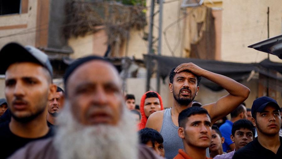 Orang-orang berkumpul saat warga Palestina berupaya mengeluarkan korban dari bawah reruntuhan rumah yang hancur akibat serangan Israel, di Khan Younis di selatan Jalur Gaza 17 Oktober 2023. (REUTERS/Ahmed Zakot)