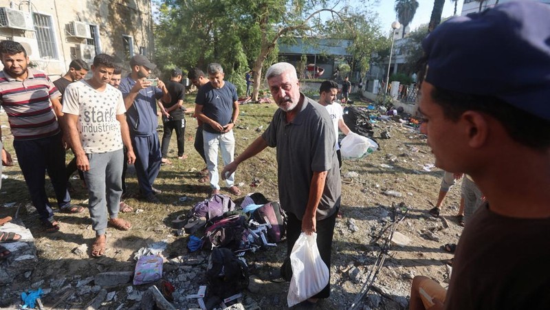 Seorang gadis yang membawa barang-barangnya berjalan di area rumah sakit Al-Ahli di mana ratusan warga Palestina tewas dalam ledakan yang saling menyalahkan oleh pejabat Israel dan Palestina, dan di mana warga Palestina yang meninggalkan rumah mereka berlindung di tengah konflik yang sedang berlangsung dengan Israel, di Kota Gaza, 18 Oktober 2023. (REUTERS/Mohammed Al-Masri)