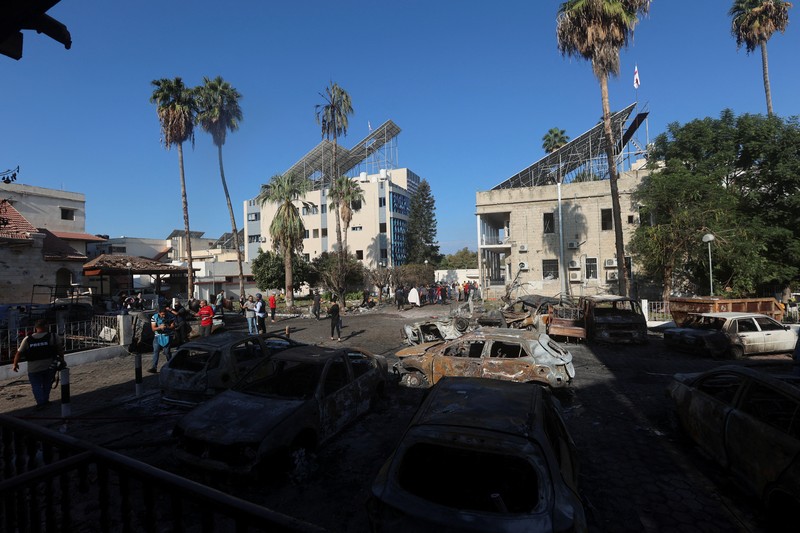 Seorang gadis yang membawa barang-barangnya berjalan di area rumah sakit Al-Ahli di mana ratusan warga Palestina tewas dalam ledakan yang saling menyalahkan oleh pejabat Israel dan Palestina, dan di mana warga Palestina yang meninggalkan rumah mereka berlindung di tengah konflik yang sedang berlangsung dengan Israel, di Kota Gaza, 18 Oktober 2023. (REUTERS/Mohammed Al-Masri)