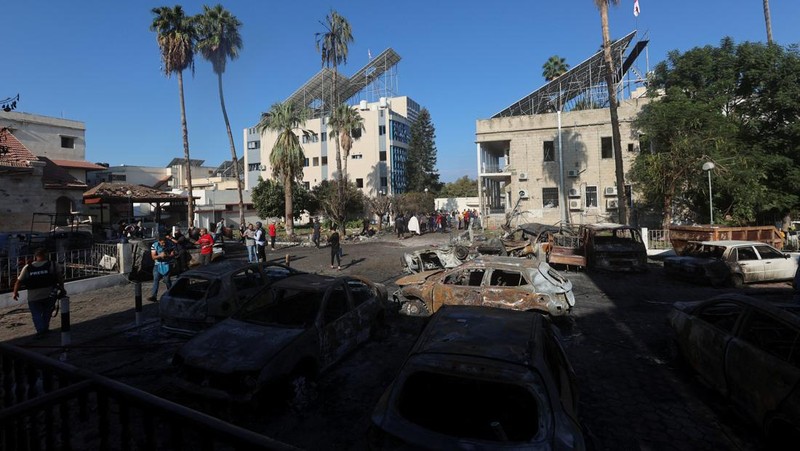 Seorang gadis yang membawa barang-barangnya berjalan di area rumah sakit Al-Ahli di mana ratusan warga Palestina tewas dalam ledakan yang saling menyalahkan oleh pejabat Israel dan Palestina, dan di mana warga Palestina yang meninggalkan rumah mereka berlindung di tengah konflik yang sedang berlangsung dengan Israel, di Kota Gaza, 18 Oktober 2023. (REUTERS/Mohammed Al-Masri)