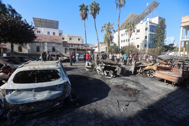 Seorang gadis yang membawa barang-barangnya berjalan di area rumah sakit Al-Ahli di mana ratusan warga Palestina tewas dalam ledakan yang saling menyalahkan oleh pejabat Israel dan Palestina, dan di mana warga Palestina yang meninggalkan rumah mereka berlindung di tengah konflik yang sedang berlangsung dengan Israel, di Kota Gaza, 18 Oktober 2023. (REUTERS/Mohammed Al-Masri)