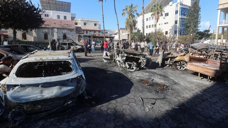 Seorang gadis yang membawa barang-barangnya berjalan di area rumah sakit Al-Ahli di mana ratusan warga Palestina tewas dalam ledakan yang saling menyalahkan oleh pejabat Israel dan Palestina, dan di mana warga Palestina yang meninggalkan rumah mereka berlindung di tengah konflik yang sedang berlangsung dengan Israel, di Kota Gaza, 18 Oktober 2023. (REUTERS/Mohammed Al-Masri)