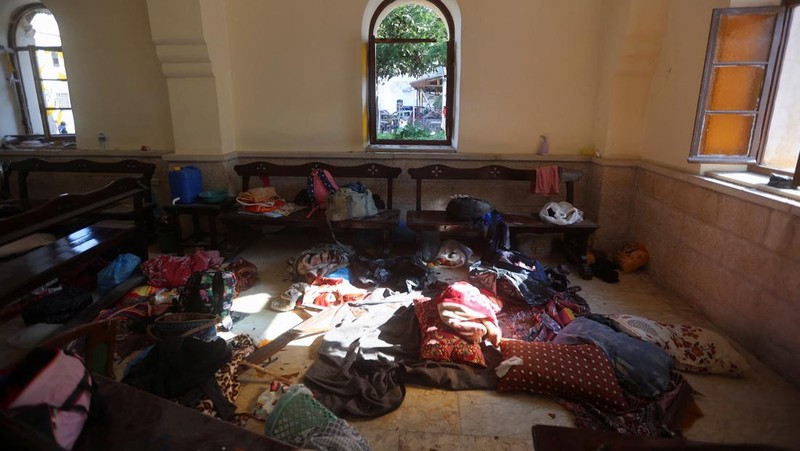 Seorang gadis yang membawa barang-barangnya berjalan di area rumah sakit Al-Ahli di mana ratusan warga Palestina tewas dalam ledakan yang saling menyalahkan oleh pejabat Israel dan Palestina, dan di mana warga Palestina yang meninggalkan rumah mereka berlindung di tengah konflik yang sedang berlangsung dengan Israel, di Kota Gaza, 18 Oktober 2023. (REUTERS/Mohammed Al-Masri)