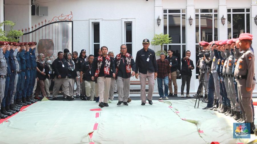 Petugas membersihkan logo KPU di kawasan gedung KPU, Jakarta, Rabu,(18/10/2023). (CNBC Indonesia/Muhammad Sabki)