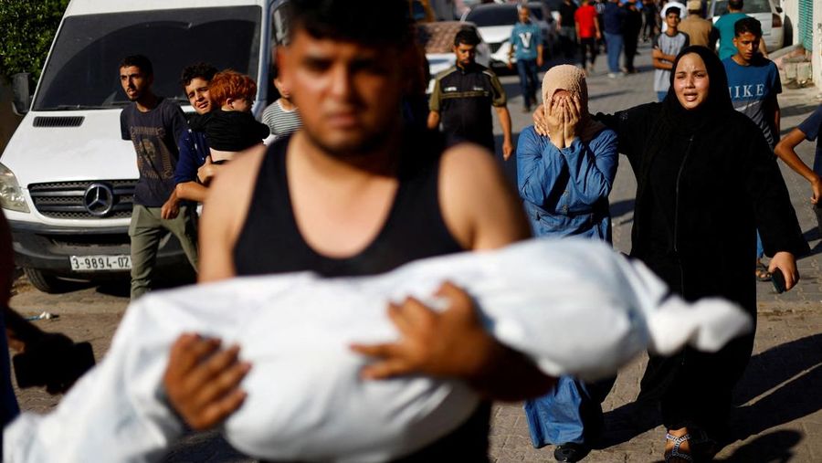 Seorang wanita memeluk jenazah seorang anak Palestina yang tewas dalam serangan Israel, di sebuah rumah sakit di Khan Younis di Jalur Gaza selatan, 17 Oktober 2023. (REUTERS/Mohammed Salem)