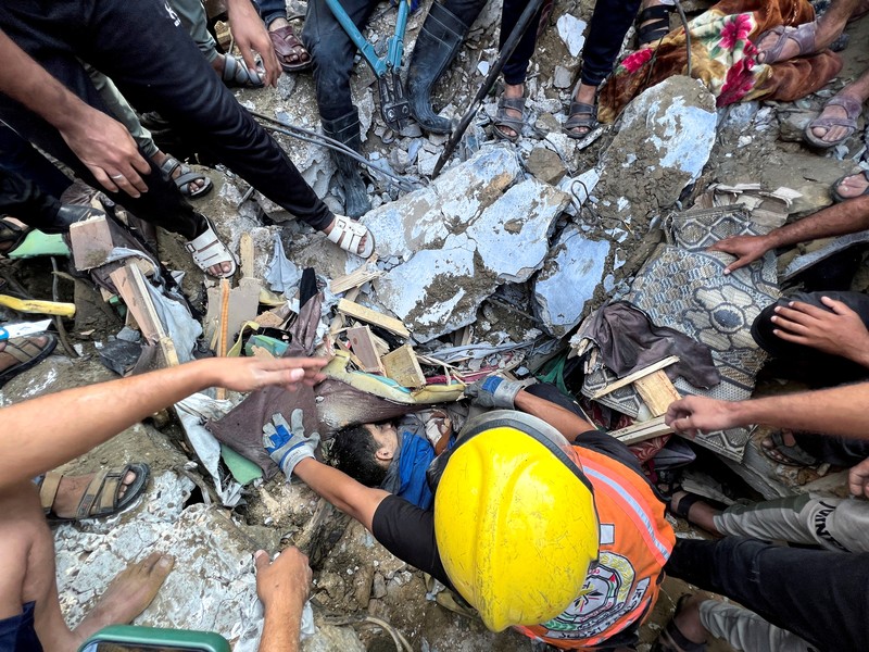 Seorang warga menolong anak yang tertimpa reruntuhan bangunan akibat serangan udara Israel di Jalur Gaza. (REUTERS/Mohammed Salem) Seorang warga menolong anak yang tertimpa reruntuhan bangunan akibat serangan udara Israel di Jalur Gaza. (REUTERS/Mohammed Salem)