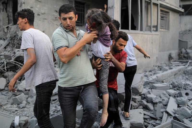 Seorang warga menolong anak yang tertimpa reruntuhan bangunan akibat serangan udara Israel di Jalur Gaza. (REUTERS/Mohammed Salem) Seorang warga menolong anak yang tertimpa reruntuhan bangunan akibat serangan udara Israel di Jalur Gaza. (REUTERS/Mohammed Salem)