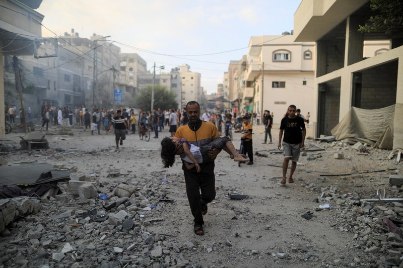 Seorang warga menolong anak yang tertimpa reruntuhan bangunan akibat serangan udara Israel di Jalur Gaza. (REUTERS/Mohammed Salem) Seorang warga menolong anak yang tertimpa reruntuhan bangunan akibat serangan udara Israel di Jalur Gaza. (REUTERS/Mohammed Salem)