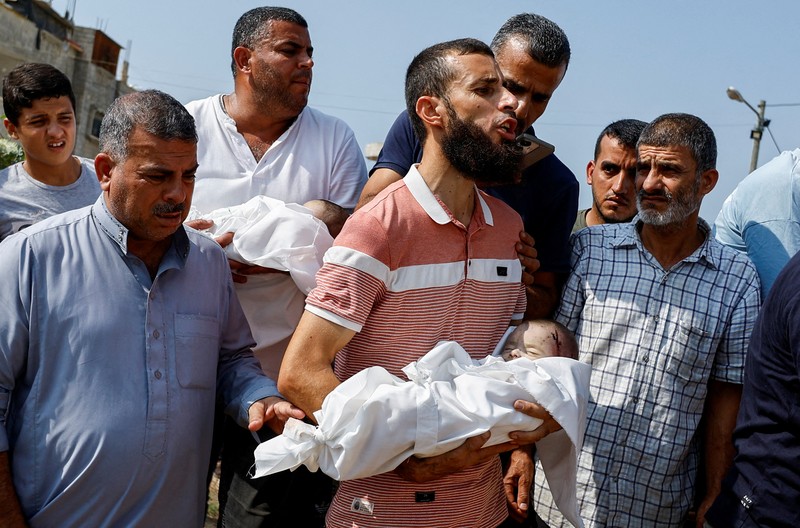 Seorang warga menolong anak yang tertimpa reruntuhan bangunan akibat serangan udara Israel di Jalur Gaza. (REUTERS/Mohammed Salem) Seorang warga menolong anak yang tertimpa reruntuhan bangunan akibat serangan udara Israel di Jalur Gaza. (REUTERS/Mohammed Salem)