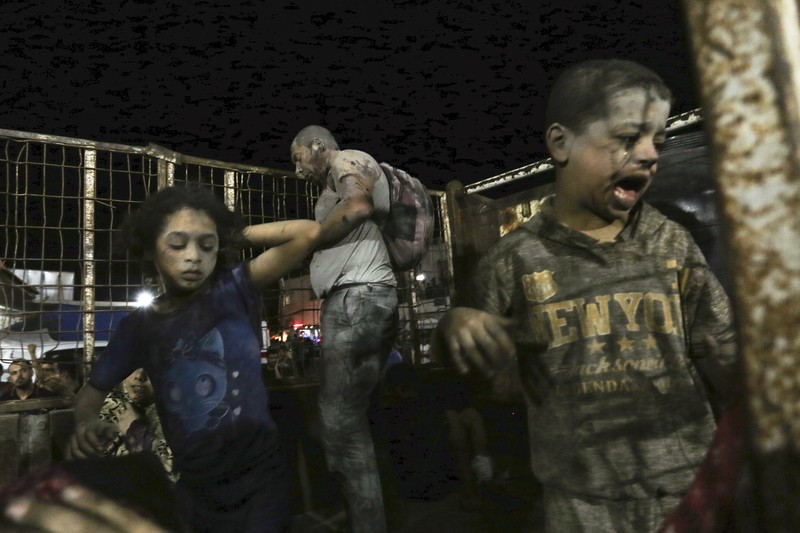 Wounded Palestinians arrive at the al-Shifa hospital, on a truck, following Israeli airstrikes on Gaza City, central Gaza Strip, Thursday, Oct. 19, 2023. (AP Photo/Abed Khaled)