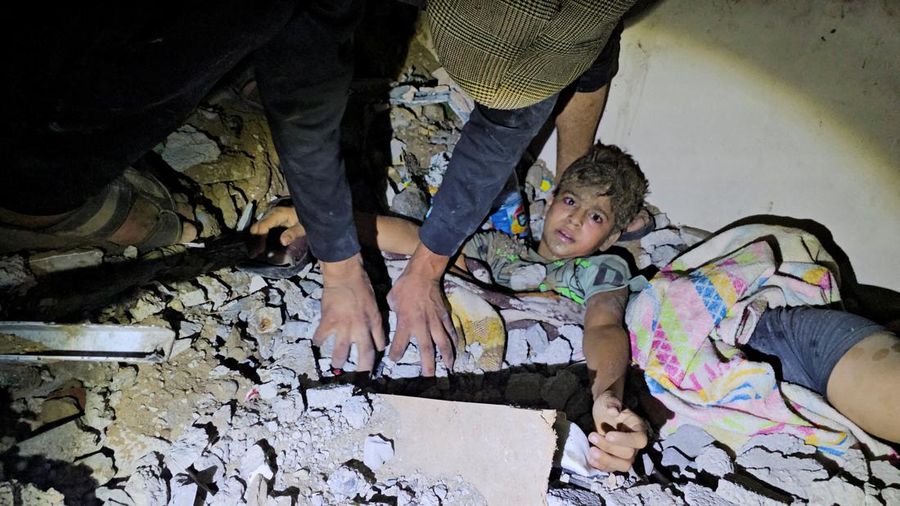 Palestinians work to rescue a boy trapped in the rubble following an Israeli strike on a house in Jabalia in the northern Gaza Strip, October 19, 2023. REUTERS/Anas al-Shareef TPX IMAGES OF THE DAY