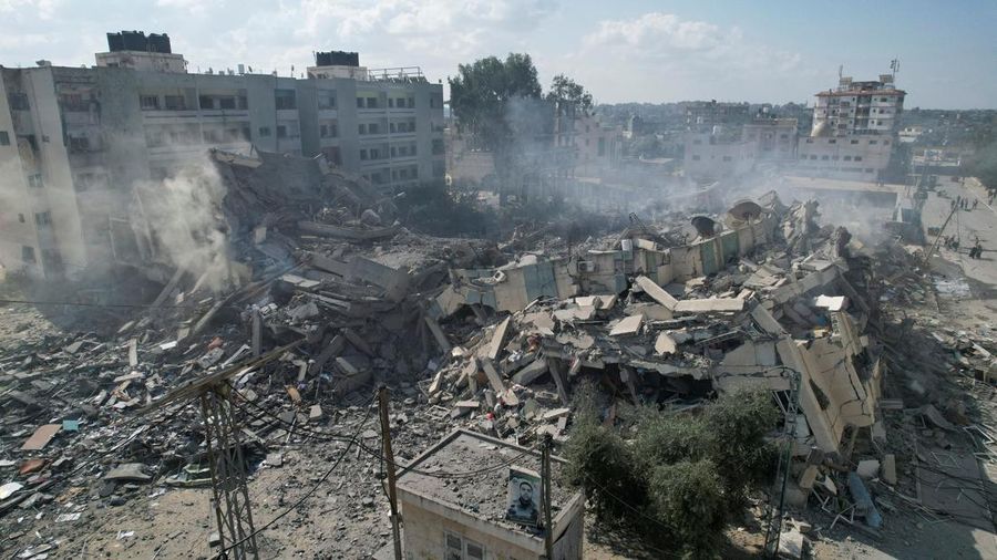 Rockets are fired from the Gaza Strip toward Israel over destroyed buildings following Israeli airstrikes on Gaza City, central Gaza Strip, Thursday, Oct. 19, 2023. (AP Photo/Mohammed Dahman)