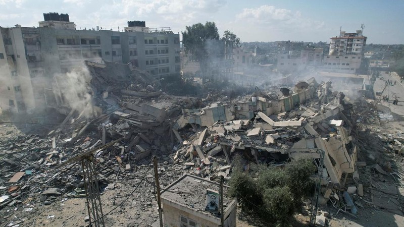Rockets are fired from the Gaza Strip toward Israel over destroyed buildings following Israeli airstrikes on Gaza City, central Gaza Strip, Thursday, Oct. 19, 2023. (AP Photo/Mohammed Dahman)
