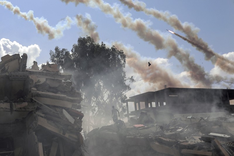 Israel Palestinians Daily Photo Gallery Rockets are fired from the Gaza Strip toward Israel over destroyed buildings following Israeli airstrikes on Gaza City, central Gaza Strip, Thursday, Oct. 19, 2023. (AP Photo/Mohammed Dahman)