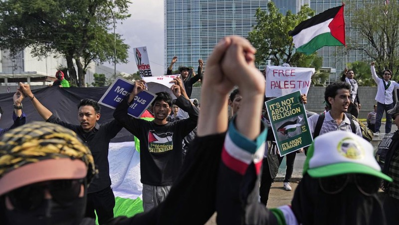 Seorang pengunjuk rasa memperlihatkan poster Perdana Menteri Israel Benjamin Netanyahu yang dirusak selama unjuk rasa mendukung rakyat Palestina di luar Kementerian Luar Negeri Indonesia di Jakarta, Indonesia, Jumat, 20 Oktober 2023. Ratusan orang melancarkan protes di ibu kota Indonesia pada hari Jumat untuk mengecam kelompok tersebut. Dukungan Amerika terhadap Israel dan menuntut diakhirinya serangan udara Israel di Jalur Gaza. (AP Photo/Dita Alangkara)
