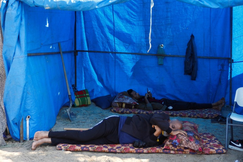 Warga Palestina, yang meninggalkan rumah mereka di tengah serangan Israel, berlindung di tenda kamp di sebuah pusat yang dikelola PBB, setelah Israel menyerukan agar lebih dari 1 juta warga sipil di Gaza utara untuk pindah ke selatan, di Khan Younis di Jalur Gaza selatan, Oktober 19 Agustus 2023. REUTERS/Ibraheem Abu Mustafa