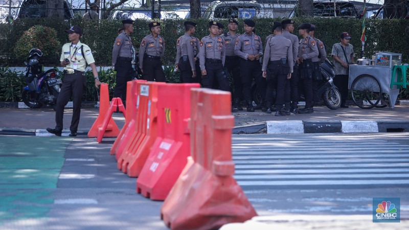 Petugas kepoilisian berjaga saat penutupan ruas jalan Medan Merdeka Barat, Jakarta, Jumat (20/10/2023). (CNBC Indonesia/Faisal Rahman)