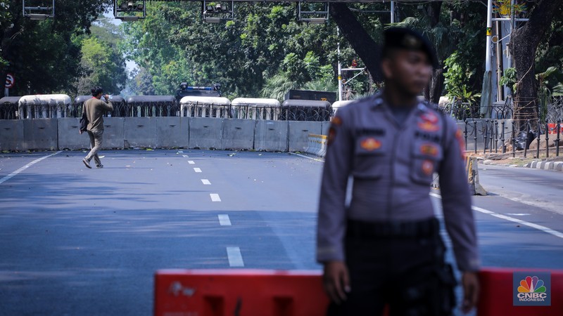 Petugas kepoilisian berjaga saat penutupan ruas jalan Medan Merdeka Barat, Jakarta, Jumat (20/10/2023). (CNBC Indonesia/Faisal Rahman)