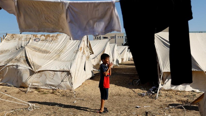 Warga Palestina, yang meninggalkan rumah mereka di tengah serangan Israel, berlindung di tenda kamp di sebuah pusat yang dikelola PBB, setelah Israel menyerukan agar lebih dari 1 juta warga sipil di Gaza utara untuk pindah ke selatan, di Khan Younis di Jalur Gaza selatan, Oktober 19 Agustus 2023. REUTERS/Ibraheem Abu Mustafa