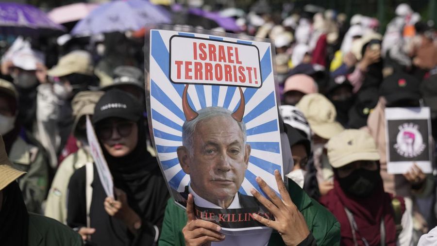 Seorang pengunjuk rasa memperlihatkan poster Perdana Menteri Israel Benjamin Netanyahu yang dirusak selama unjuk rasa mendukung rakyat Palestina di luar Kementerian Luar Negeri Indonesia di Jakarta, Indonesia, Jumat, 20 Oktober 2023. Ratusan orang melancarkan protes di ibu kota Indonesia pada hari Jumat untuk mengecam kelompok tersebut. Dukungan Amerika terhadap Israel dan menuntut diakhirinya serangan udara Israel di Jalur Gaza. (AP Photo/Dita Alangkara)