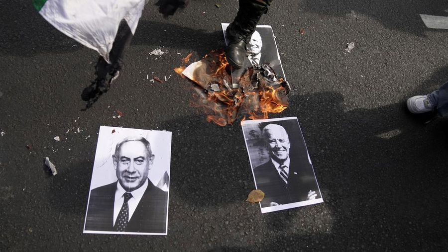 Seorang pengunjuk rasa memperlihatkan poster Perdana Menteri Israel Benjamin Netanyahu yang dirusak selama unjuk rasa mendukung rakyat Palestina di luar Kementerian Luar Negeri Indonesia di Jakarta, Indonesia, Jumat, 20 Oktober 2023. Ratusan orang melancarkan protes di ibu kota Indonesia pada hari Jumat untuk mengecam kelompok tersebut. Dukungan Amerika terhadap Israel dan menuntut diakhirinya serangan udara Israel di Jalur Gaza. (AP Photo/Dita Alangkara)