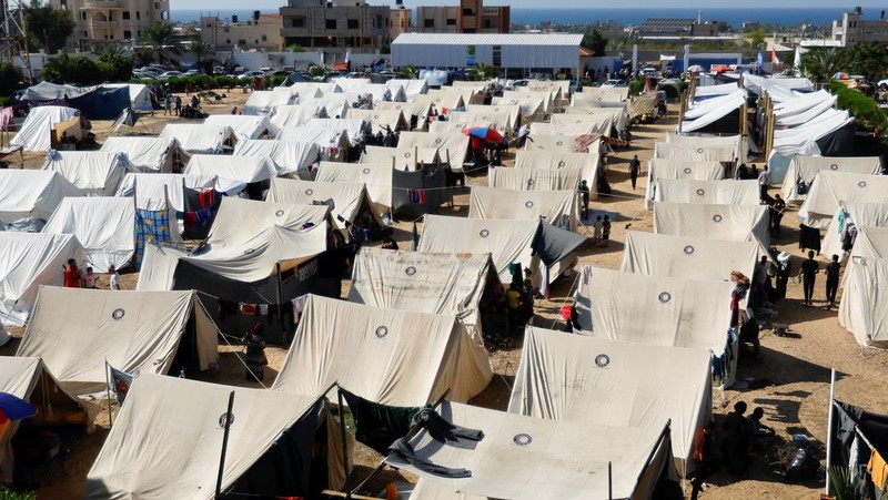 Warga Palestina, yang meninggalkan rumah mereka di tengah serangan Israel, berlindung di tenda kamp di sebuah pusat yang dikelola PBB, setelah Israel menyerukan agar lebih dari 1 juta warga sipil di Gaza utara untuk pindah ke selatan, di Khan Younis di Jalur Gaza selatan, Oktober 19 Agustus 2023. REUTERS/Ibraheem Abu Mustafa
