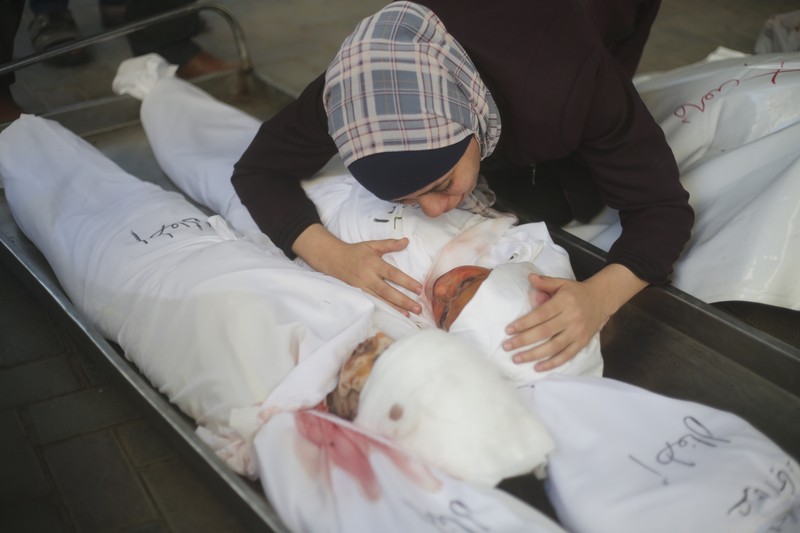 Keluarga berduka atas tewasnya korban pemboman Israel di Jalur Gaza di Rafah pada Sabtu, (21/10/2023). (AP Photo/Hatem Ali)