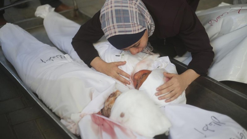 Keluarga berduka atas tewasnya korban pemboman Israel di Jalur Gaza di Rafah pada Sabtu, (21/10/2023). (AP Photo/Hatem Ali)