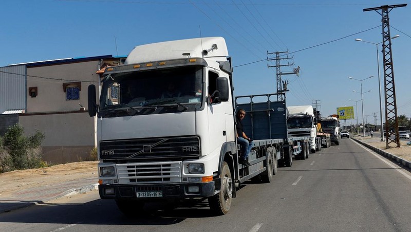Truk-truk yang membawa bantuan kemanusiaan dari Mesir ke Gaza berada di perbatasan Rafah, selatan Jalur Gaza, Sabtu (21/10/2023). (REUTERS/Ibraheem Abu Mustafa)