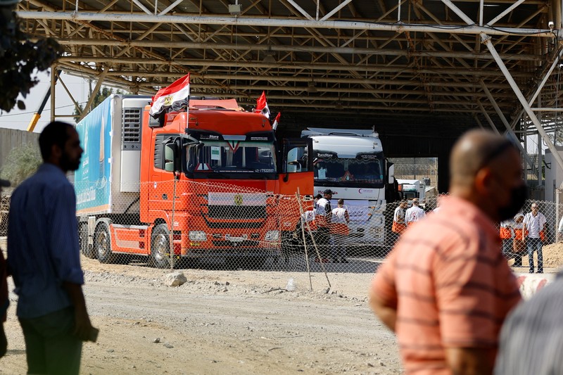 Truk-truk yang membawa bantuan kemanusiaan dari Mesir ke Gaza berada di perbatasan Rafah, selatan Jalur Gaza, Sabtu (21/10/2023). (REUTERS/Ibraheem Abu Mustafa)