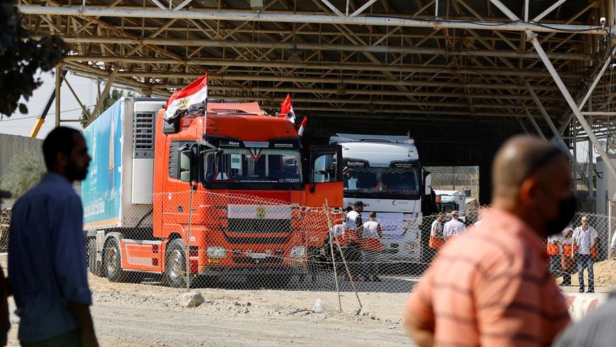 Truk-truk yang membawa bantuan kemanusiaan dari Mesir ke Gaza berada di perbatasan Rafah, selatan Jalur Gaza, Sabtu (21/10/2023). (REUTERS/Ibraheem Abu Mustafa)