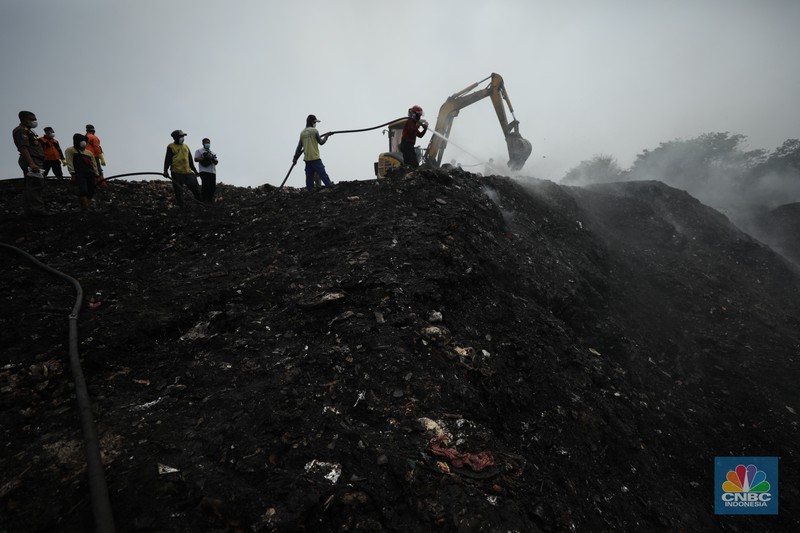Petugas pemadam kebakaran melakukan pendinginan sisa kebakaran di Tempat Pemrosesan Akhir (TPA) Rawa Kucing, Kelurahan Kedaung Wetan,  Neglasari, Tangerang, Banten, Senin (23/10/2023).  (CNBC Indonesia/Tri Susilo)