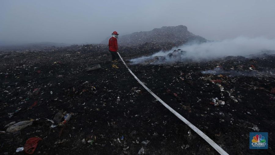 Petugas pemadam kebakaran melakukan pendinginan sisa kebakaran di Tempat Pemrosesan Akhir (TPA) Rawa Kucing, Kelurahan Kedaung Wetan, Neglasari, Tangerang, Banten, Senin (23/10/2023). (CNBC Indonesia/Tri Susilo)