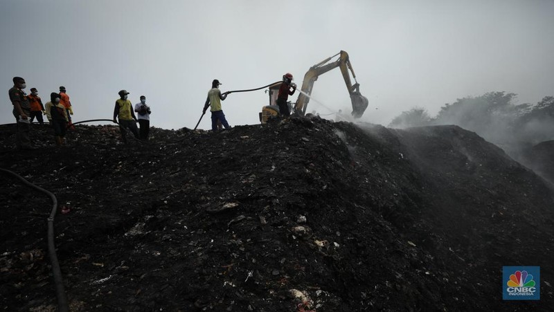 Petugas pemadam kebakaran melakukan pendinginan sisa kebakaran di Tempat Pemrosesan Akhir (TPA) Rawa Kucing, Kelurahan Kedaung Wetan,  Neglasari, Tangerang, Banten, Senin (23/10/2023).  (CNBC Indonesia/Tri Susilo)