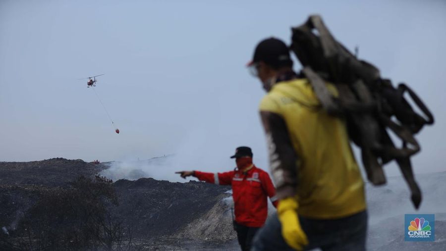 Petugas pemadam kebakaran melakukan pendinginan sisa kebakaran di Tempat Pemrosesan Akhir (TPA) Rawa Kucing, Kelurahan Kedaung Wetan, Neglasari, Tangerang, Banten, Senin (23/10/2023). (CNBC Indonesia/Tri Susilo)