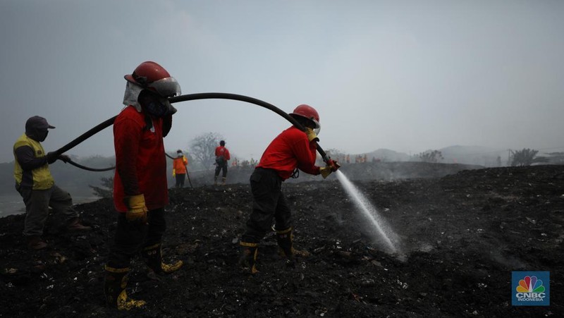 Petugas pemadam kebakaran melakukan pendinginan sisa kebakaran di Tempat Pemrosesan Akhir (TPA) Rawa Kucing, Kelurahan Kedaung Wetan,  Neglasari, Tangerang, Banten, Senin (23/10/2023).  (CNBC Indonesia/Tri Susilo)