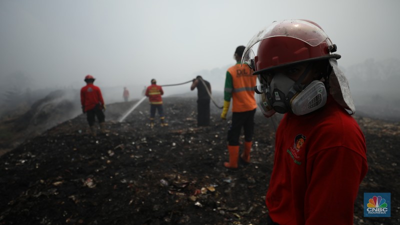 Petugas pemadam kebakaran melakukan pendinginan sisa kebakaran di Tempat Pemrosesan Akhir (TPA) Rawa Kucing, Kelurahan Kedaung Wetan, Neglasari, Tangerang, Banten, Senin (23/10/2023). (CNBC Indonesia/Tri Susilo)