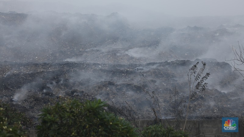 Petugas pemadam kebakaran melakukan pendinginan sisa kebakaran di Tempat Pemrosesan Akhir (TPA) Rawa Kucing, Kelurahan Kedaung Wetan,  Neglasari, Tangerang, Banten, Senin (23/10/2023).  (CNBC Indonesia/Tri Susilo)