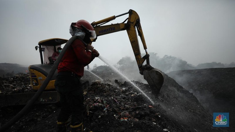 Petugas pemadam kebakaran melakukan pendinginan sisa kebakaran di Tempat Pemrosesan Akhir (TPA) Rawa Kucing, Kelurahan Kedaung Wetan,  Neglasari, Tangerang, Banten, Senin (23/10/2023).  (CNBC Indonesia/Tri Susilo)