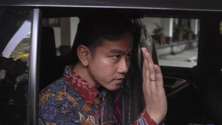 Gibran Rakabuming Raka, Wali Kota Surakarta yang juga putra sulung Presiden Indonesia Joko Widodo, melambai kepada wartawan saat meninggalkan kantornya di Surakarta, Jawa Tengah, Indonesia, Senin, 23 Oktober 2023. (AP Photo/Hisyam Umar)