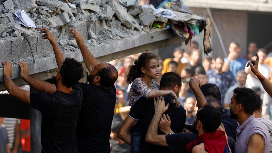 Seorang warga Palestina membawa korban anak-anak di lokasi serangan Israel terhadap sebuah rumah, di Khan Younis, di selatan Jalur Gaza, 24 Oktober 2023. (REUTERS/Ibraheem Abu Mustafa)