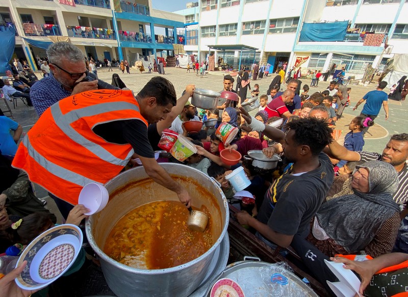 Warga Palestin antre makanan yang dibagikan oleh relawan PBB di kamp pengungsian, Rafah, Jalur Gaza Selatan, Senin(23/10/12023). (REUTERS/Mahmoud al-Masri)