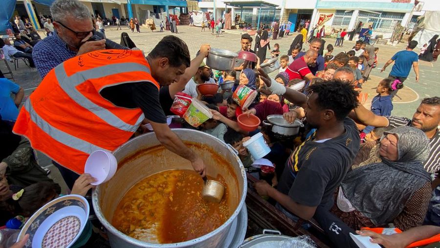 Warga Palestin antre makanan yang dibagikan oleh relawan PBB di kamp pengungsian, Rafah, Jalur Gaza Selatan, Senin(23/10/12023). (REUTERS/Mahmoud al-Masri)