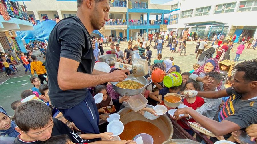 Warga Palestin antre makanan yang dibagikan oleh relawan PBB di kamp pengungsian, Rafah, Jalur Gaza Selatan, Senin(23/10/12023). (REUTERS/Mahmoud al-Masri)