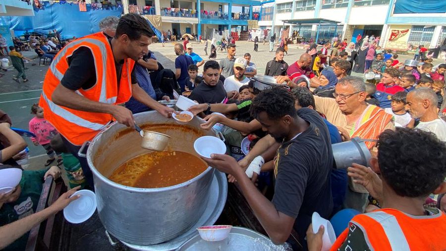 Warga Palestin antre makanan yang dibagikan oleh relawan PBB di kamp pengungsian, Rafah, Jalur Gaza Selatan, Senin(23/10/12023). (REUTERS/Mahmoud al-Masri)