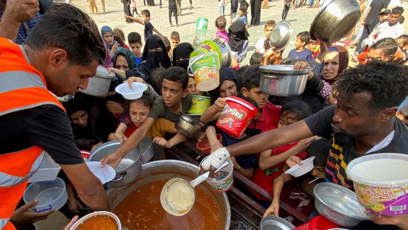 Warga Palestin antre makanan yang dibagikan oleh relawan PBB di kamp pengungsian, Rafah, Jalur Gaza Selatan, Senin(23/10/12023). (REUTERS/Mahmoud al-Masri)