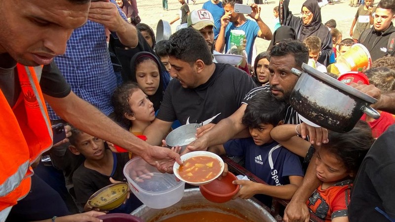 Warga Palestin antre makanan yang dibagikan oleh relawan PBB di kamp pengungsian, Rafah, Jalur Gaza Selatan, Senin(23/10/12023). (REUTERS/Mahmoud al-Masri)