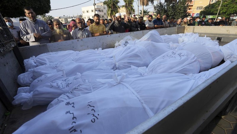 Warga Palestina berkumpul di lokasi serangan Israel terhadap sebuah rumah di Khan Younis, di Jalur Gaza selatan, 24 Oktober 2023. (REUTERS/Mohammed Salem)